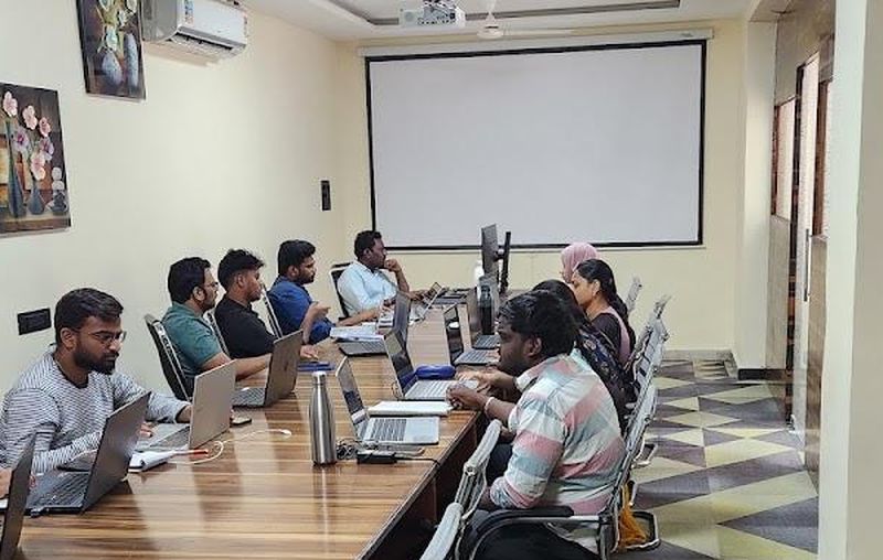 The Ameerpet training room, with laptops along a long table facing the projector screen