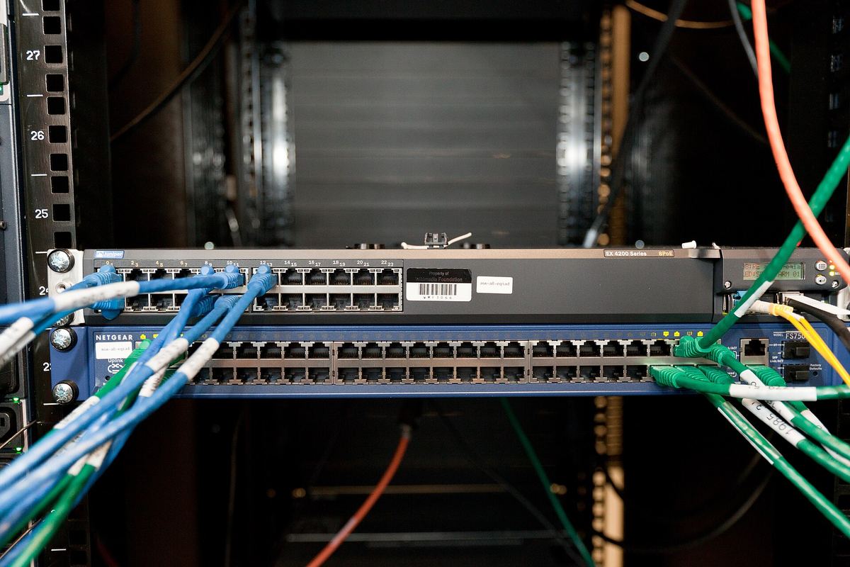 Network switches with blue and green patch cables in a rack